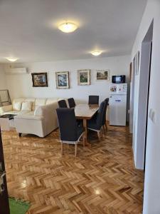 a living room with a table and chairs and a kitchen at Apartmani Štefica in Dramalj