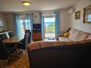 a living room with a couch and a dining room table at Apartmani Štefica in Dramalj