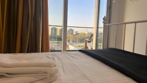 Una cama con sábanas blancas y una ventana con vistas. en Marius Apartment, en Bucarest