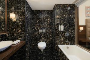 Un baño con bañera, inodoro y lavabo. en Trinity Whitefield Bengaluru, en Bangalore 20 fotos más