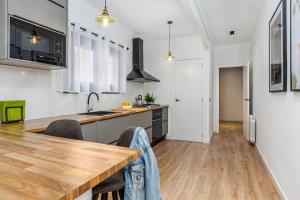 a kitchen with a wooden table and a counter top at Simply Stunning - Hidden Gem, Heart Of Poble Sec in Barcelona