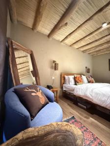 a bedroom with a bed and a chair with a pillow at Skarchan Resort Skardu in Skardu