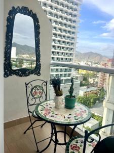 a table and chairs on a balcony with a window at Nuevo Apartaestudio en frente de la marina in Santa Marta +19 photos