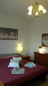 モンタルチーノにあるL'Incantoのベッドルーム1室(赤いベッド1台、トレイ付)