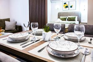 a dining room table with plates and wine glasses at Riian Luxury Apartments in Ulcinj