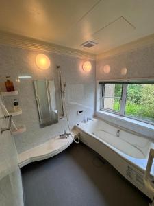 那須塩原市にあるNasu Aoki FABULOUS HOUSE - Vacation STAY 19555のバスタブと窓のあるバスルーム