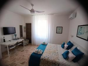 a bedroom with a bed with blue pillows and a desk at La Maison in Montallegro
