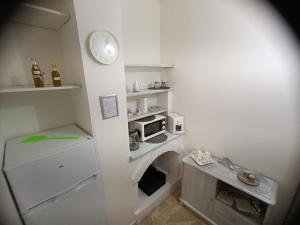 a small kitchen with a microwave and a clock on the wall at La Maison in Montallegro