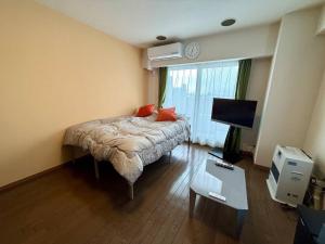 une chambre avec un lit, une télévision et une table dans l'établissement Tokan Nakanoshima Castel - Vacation STAY 19496, à Sapporo