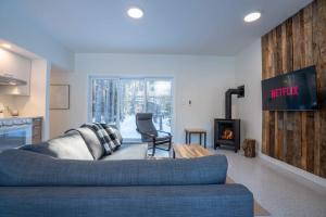 ein Wohnzimmer mit Couch und Kamin in der Unterkunft Brand New with SPA - Le Repaire du Lievre Blanc in Saint-Alexis-des-Monts + 42 Fotos