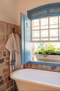 a bathroom with a sink and a window and a tub at Chateau Tiradentes in Tiradentes