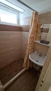 a bathroom with a shower curtain and a sink at Dami Apartman in Hajdúszoboszló +28 photos