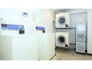 eine Waschküche mit Waschmaschine, Waschmaschine und Trockner in der Unterkunft Smile Hotel Kumagaya - Vacation STAY 64058v in Kumagaya