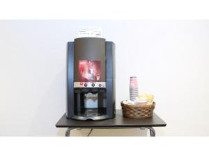 eine Kaffeemaschine auf einem Regal mit einem Korb in der Unterkunft Smile Hotel Kumagaya - Vacation STAY 64058v in Kumagaya + 26 Fotos