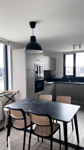 Una cocina con una mesa y sillas en una cocina. en Departamentos Natales, en Puerto Natales