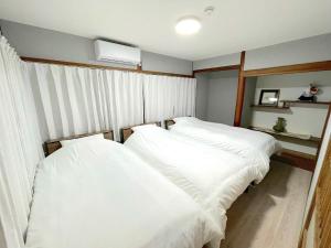 two beds in a room with white sheets at Nagasaki - House - Vacation STAY 19522 in Nagasaki