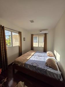 een slaapkamer met een bed en een raam bij Mathoeralaan Appartement in Paramaribo