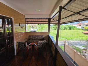 een veranda van een huis met 2 stoelen en een tafel bij Mathoeralaan Appartement in Paramaribo +5 foto's
