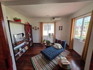 een woonkamer met een blauwe bank en een tv bij Mathoeralaan Appartement in Paramaribo