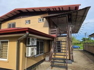 een huis met een wenteltrap ervoor bij Mathoeralaan Appartement in Paramaribo