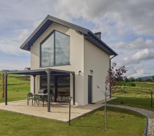 a house with glass doors and a patio at Italian House Bieszczady in Bachlawa