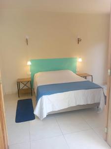 a bedroom with a large bed with a green headboard at Suíte no Jardim à Beira-Mar in Peruíbe