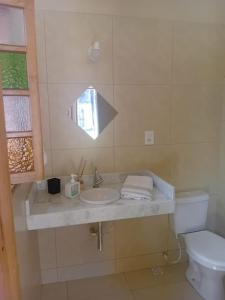 ペルイベにあるSuíte no Jardimの洗面台、トイレ、鏡のあるバスルーム