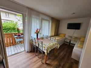 a room with a table and chairs and a balcony at Wohnung Hochbild in Überlingen