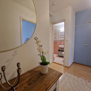 a bathroom with a mirror and a vase with flowers on a table at Porvoo Central Apartment in Porvoo