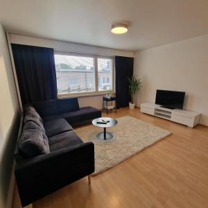 a living room with a couch and a tv at Porvoo Central Apartment in Porvoo