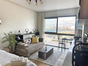 a living room with a couch and a large window at 3-marina Serena ocean-studio chic vue mer in Casablanca