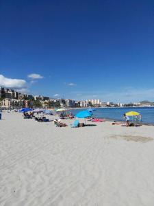 a group of people laying on a beach with umbrellas at La Vila in Villajoyosa