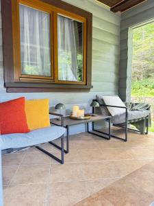 a porch with two chairs and a table and two windows at Gray House in Pilipets