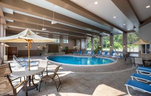 a pool in a hotel room with tables and chairs at Holiday Inn Resort Lake George - Adirondack Area by IHG in Lake George
