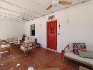 salon z czerwonymi drzwiami i białymi ścianami w obiekcie La casita del desierto, cortijo para 7 personas con piscina privada w mieście Tabernas