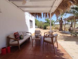 patio z kanapą, 2 krzesłami i parasolem w obiekcie La casita del desierto, cortijo para 7 personas con piscina privada w mieście Tabernas
