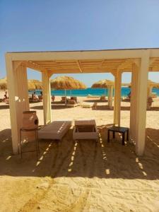 einen Strand mit Liegestühlen und Sonnenschirmen auf dem Sand in der Unterkunft Princess Resort Hurghada in Hurghada