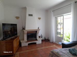a living room with a fireplace and a tv at Marcio's Home in Fernao Ferro
