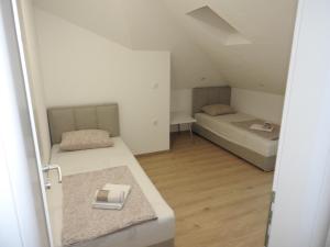 a small room with two beds and a table at Apartmani Kaić in Livno
