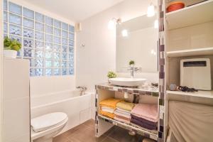 ein Badezimmer mit Waschbecken, Toilette und Badewanne in der Unterkunft Grand et charmant appartement familial, 3 chambres, et moderne avec grand jardin et parking privatif aux portes de Paris in La Garenne-Colombes