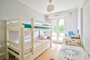 ein Schlafzimmer mit Etagenbett und Schreibtisch in der Unterkunft Grand et charmant appartement familial, 3 chambres, et moderne avec grand jardin et parking privatif aux portes de Paris in La Garenne-Colombes + 2 Fotos