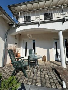 a patio with two chairs and a table and a balcony at Moselgold Apartment in Zeltingen-Rachtig