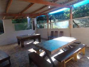 a living room with a table and a television at Chácara Sonho Meu Juquitiba SP in Juquitiba