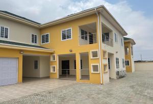 a large yellow house with a driveway at Dream Villa at Oyarifa in Oyarifa