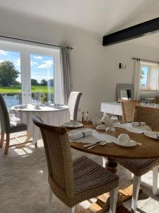 a dining room with a table and chairs and a window at Abbey Green Farm in Wem