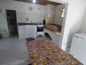 a kitchen with a table in the middle of it at Chácara Sonho Meu Juquitiba SP in Juquitiba