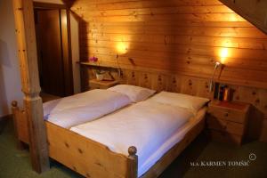 sypialnia z łóżkiem w drewnianym pokoju w obiekcie Gasthof Schluff w mieście Soprabolzano