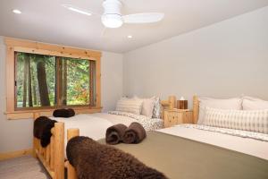 two beds in a bedroom with a window at Big Chief River Retreat-Located on Truckee River in Truckee