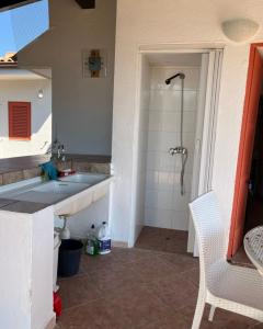 a bathroom with a sink and a shower at Vendrisine lacco rosso 1436 in Casarano