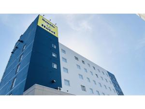 a tall blue building with a yellow sign on it at Smile Hotel Tomakomai - Vacation STAY 68898v in Tomakomai +35 photos